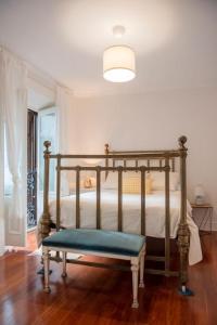 a bedroom with a bed with a bench in it at Villa colonial Jardin Algorta centro Puerto Viejo in Getxo