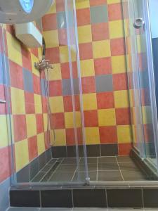 a shower in a bathroom with colorful tiles at Open Space Apartment in Belgrade