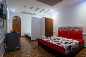 una camera da letto con un letto con cuscini rossi di Dar El Mghouchi a Chefchaouen