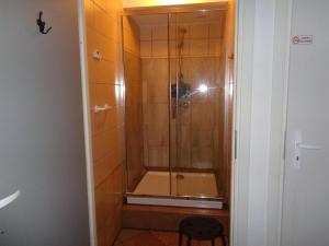 La salle de bains est pourvue d'une douche avec une porte en verre. dans l'établissement GO Hostel Rewolucji, à Łódź