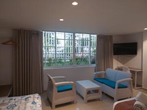 um quarto de hotel com uma cadeira de cama e uma televisão em Bahia San Andres Hospedaje em San Andrés