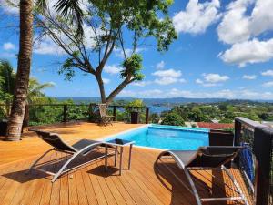 una terraza con 2 sillas y una piscina en Bamboo Villa en Port Vila
