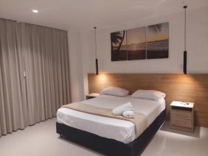 um quarto com uma cama king-size e uma mesa de cabeceira em Bahia San Andres Hospedaje em San Andrés