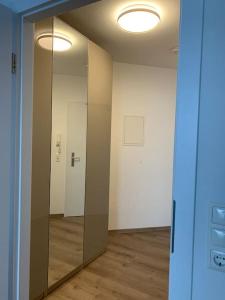 une pièce vide avec une porte en verre et un miroir dans l'établissement Eine gemütliche Einzimmerwohnung, à Ostfildern