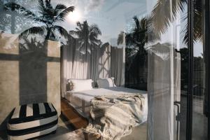 sypialnia z łóżkiem i palmami na balkonie w obiekcie Tao House Jungle Boutique Villas w mieście Ahangama