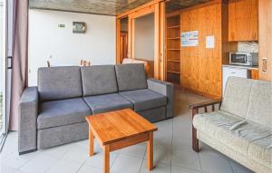 ein Wohnzimmer mit einem Sofa und einem Tisch in der Unterkunft Cozy Apartment In Freixo De Espada C With Kitchen in Freixo de Espada à Cinta