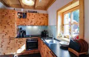 a kitchen with wooden cabinets and a sink and a window at 3 Bedroom Nice Home In Flattnitz in Flattnitz