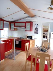 een keuken met rode kasten en een tafel met stoelen bij Casa del cristo in Solórzano