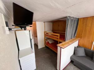 Cette petite chambre dispose d'une télévision et d'un lit. dans l'établissement Appartement rdc calme6 pers, à Eaux-Bonnes
