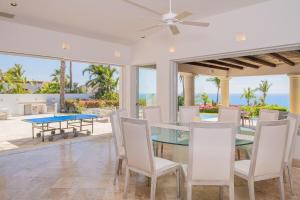 Un comedor con mesa y sillas en Stunning 6bd Villa in Palmilla! Fully Staffed w Chauffeur and Yacht included!, en San José del Cabo