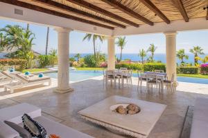 Un patio con piscina con un perro en una cama para perros. en Stunning 6bd Villa in Palmilla! Fully Staffed w Chauffeur and Yacht included!, en San José del Cabo