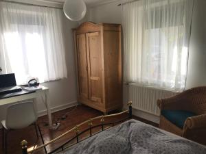 1 dormitorio con 1 cama, escritorio y armario en Privatzimmer Augsburg Rechts der Wertach, en Augsburg