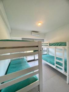 2 literas en una habitación con sábanas verdes en Positive Tower I 2A en Pinamar
