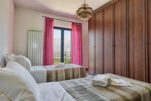 a bedroom with two beds and a window with pink curtains at Agriturismo Statale 17 in Poggio Picenze