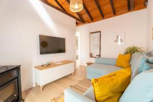 a living room with a couch and a tv at Vivienda Vacacional Rosa Blanca in Arure
