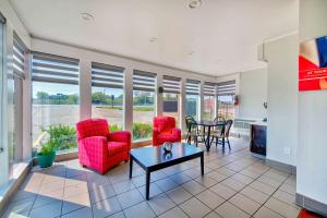 a living room with red chairs and a table at Motel 6-Fort Worth, TX - White Settlement in Fort Worth