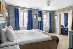 a bedroom with a large bed with blue curtains at Best Western Hotel Royal in Malmö