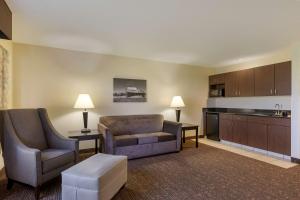 uma sala de estar com um sofá e uma cadeira e uma cozinha em Best Western Plus Omaha Airport Inn em Carter Lake