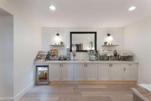 a kitchen with white cabinets and a mirror at BEST WESTERN the Inn of Los Gatos in Los Gatos