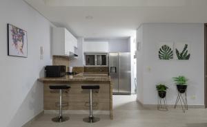 cocina con encimera y taburetes en una habitación en Beach Apartment Jacuzzi Wifi in Santa Marta by Huespedia 402, en Santa Marta