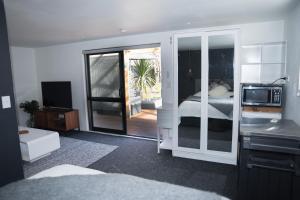 Zimmer mit einem Schlafzimmer mit einem Bett und einer Mikrowelle in der Unterkunft Bach On Daniel in Martinborough 