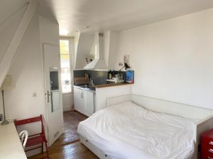 a bedroom with a white bed and a kitchen at Amazing view in Montmartre in Paris