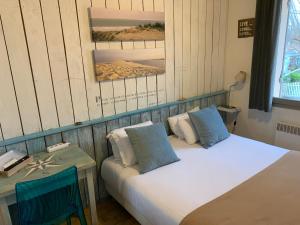 - une chambre avec 2 lits et une table avec un lit sidx sidx dans l'établissement LOGIS HOTELS - Hôtel et Restaurant L'Océana, à Lanton