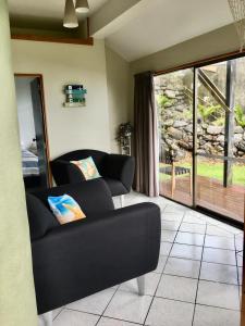 a living room with a couch and a large window at 90 Mile Paradise Ahipara in Ahipara