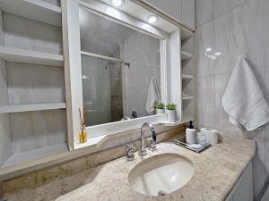 a bathroom with a sink and a mirror at Apartamento c/vista p o mar no Leme in Rio de Janeiro