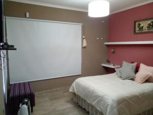um quarto com uma cama branca e um grande ecrã em La Fermina em Villa Giardino