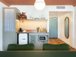 a kitchen with two green chairs in a room at Palihouse West Hollywood in Los Angeles