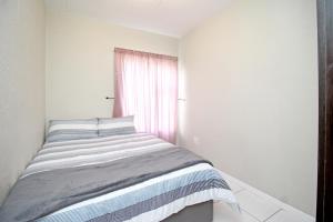 a bed in a white room with a window at GREENWICH 2 bedroom 2 bath serv apart with 24hrs electricity in Sandton