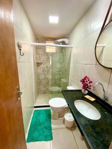 a bathroom with a sink and a toilet and a mirror at Casa Porto 14 in Porto De Galinhas