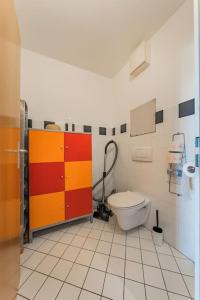 W łazience znajduje się toaleta oraz czerwona i żółta szafka. w obiekcie Spektakuläres Apartment ✩ 7. Stock ✩ kostenlose Parkgarage w Wiedniu