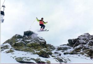 una persona en esquís saltando sobre algunas rocas en Hotel Rural Huerta del Laurel, en Monachil