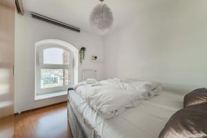biały pokój z łóżkiem i oknem w obiekcie Spektakuläres Apartment ✩ 7. Stock ✩ kostenlose Parkgarage w Wiedniu