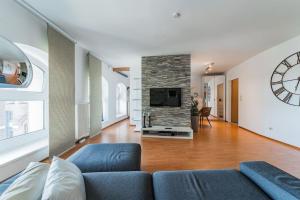 salon z niebieską kanapą i telewizorem w obiekcie Spektakuläres Apartment ✩ 7. Stock ✩ kostenlose Parkgarage w Wiedniu