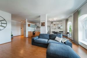 uma sala de estar com um sofá azul e uma cozinha em Spektakuläres Apartment ✩ 7. Stock ✩ kostenlose Parkgarage em Viena