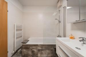 biała łazienka z wanną i umywalką w obiekcie Spektakuläres Apartment ✩ 7. Stock ✩ kostenlose Parkgarage w Wiedniu