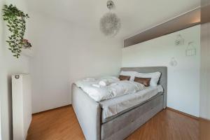 biały pokój z łóżkiem w rogu w obiekcie Spektakuläres Apartment ✩ 7. Stock ✩ kostenlose Parkgarage w Wiedniu