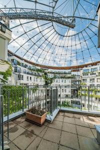 balkon z szklanym dachem i roślinami w budynku w obiekcie Spektakuläres Apartment ✩ 7. Stock ✩ kostenlose Parkgarage w Wiedniu