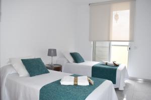 a bedroom with two beds with green and white sheets at apartamento sabare rambla in Frontera
