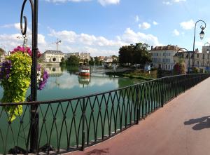 un ponte sopra un fiume con dei fiori sopra di Paris & Disney - LES BORDS DE MARNE a Meaux