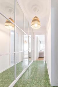 a hallway with a green floor and large windows at De la cama a la mar in Luanco