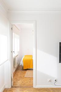 an open door to a bedroom with a yellow bed at De la cama a la mar in Luanco