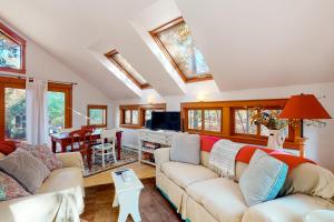 a living room with two couches and a tv at Little Brown House in Glen Arbor