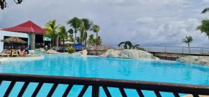 een groot zwembad met blauw water in een resort bij Studio Lucie à MANGANAO in Saint-François