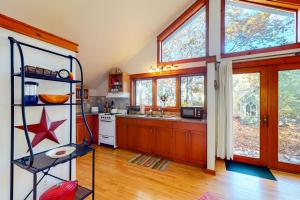 a kitchen with wooden floors and windows and a counter top at Little Brown House in Glen Arbor