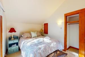 a bedroom with a bed and a table with a lamp at Little Brown House in Glen Arbor