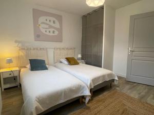 a bedroom with two beds and a lamp and a mirror at La Casa Montussan in Montussan